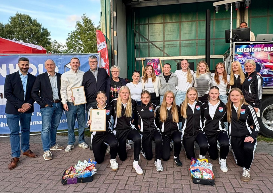 Beide Teams und Bürgermeister Dänekas und Samtgemeindebürgermeister Busboom, sowie Trainer der Mannschaft vor der Bühne