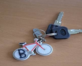 Foto vom Schlüsslbund (zwei Schlüssel mit schwarzer Kappe und Schlüsselanhänger mit Fahrradmotiv) 