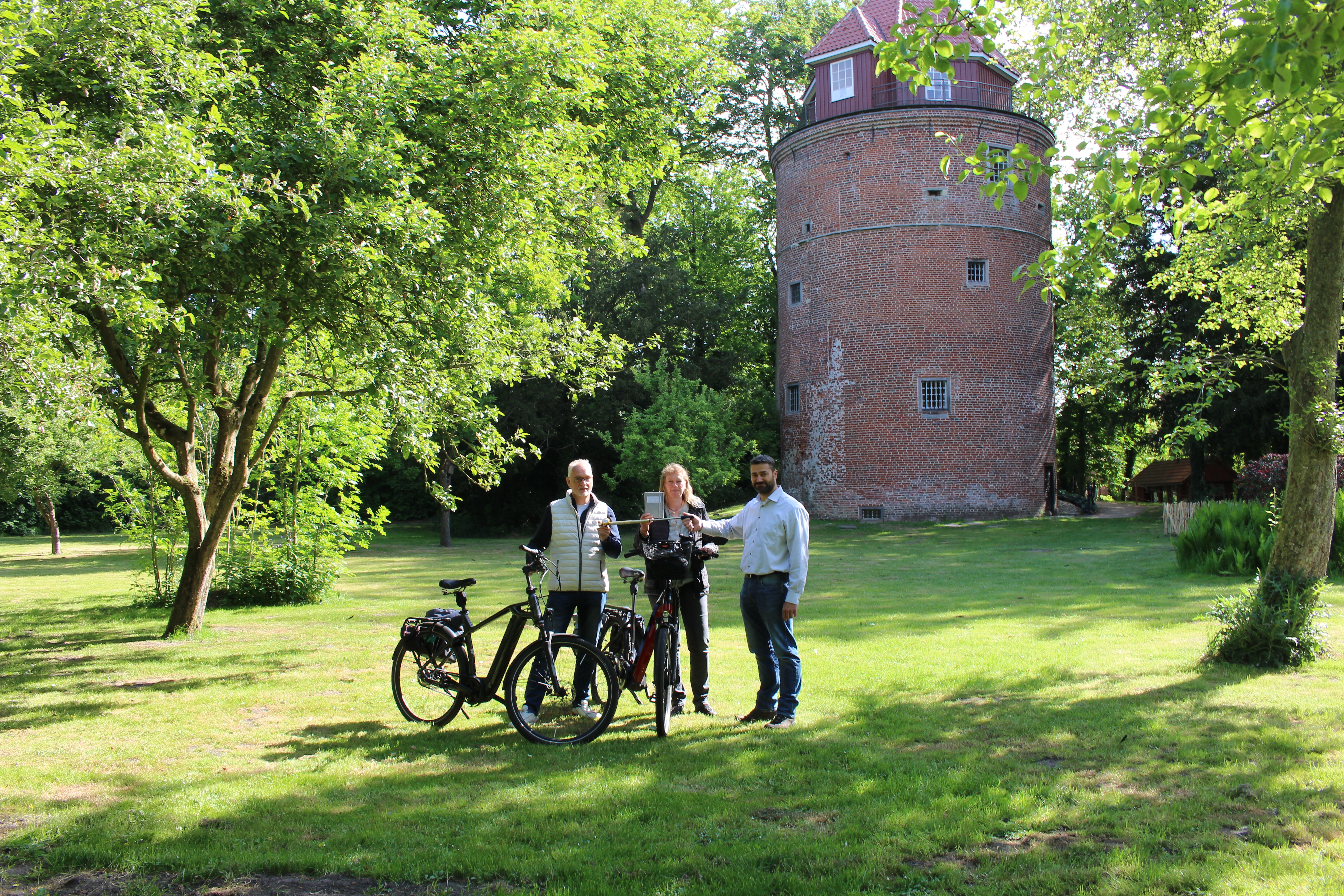 Bild von der Staffelstab-Übergabe vor dem Burgturm Stickhausen