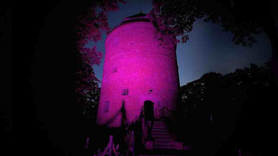 Foto vom beleuchteten Burgturm Stickhausen in pink